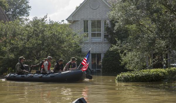 Marines with Charlie Company, 4th Reconnaissance Battalion, 4th Marine Division, Marine Forces Reserve, along with a member of the Texas Highway Patrol and Texas State Guard, patrol past a flooded house in Houston, Texas, Aug. 31, 2017. Hurricane Harvey landed Aug. 25, 2017, flooding thousands of homes and displaced over 30,000 people. (U.S. Marine Corps photo by Lance Cpl. Niles Lee/Released)