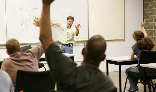 Adult education class raising hands to ask questions