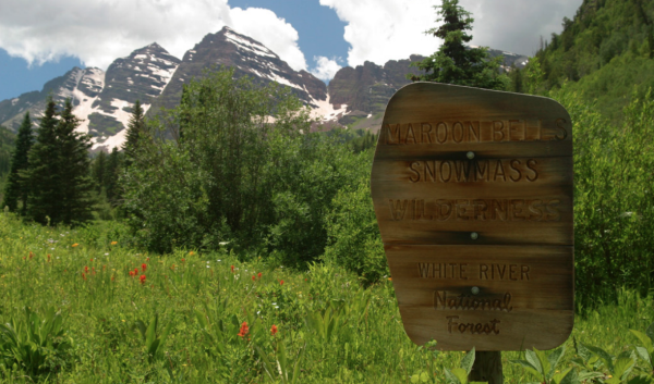 Wooden sign in front of Maroon Bells mountains